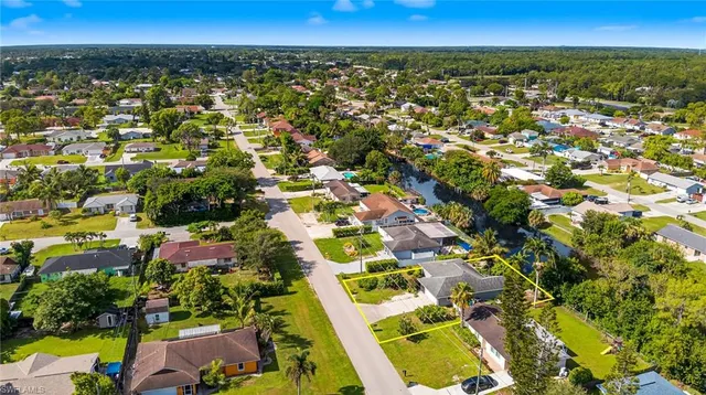 an aerial view of residential houses with outdoor space and trees