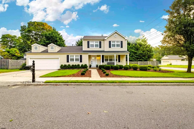 a view of house with a big yard and potted plants