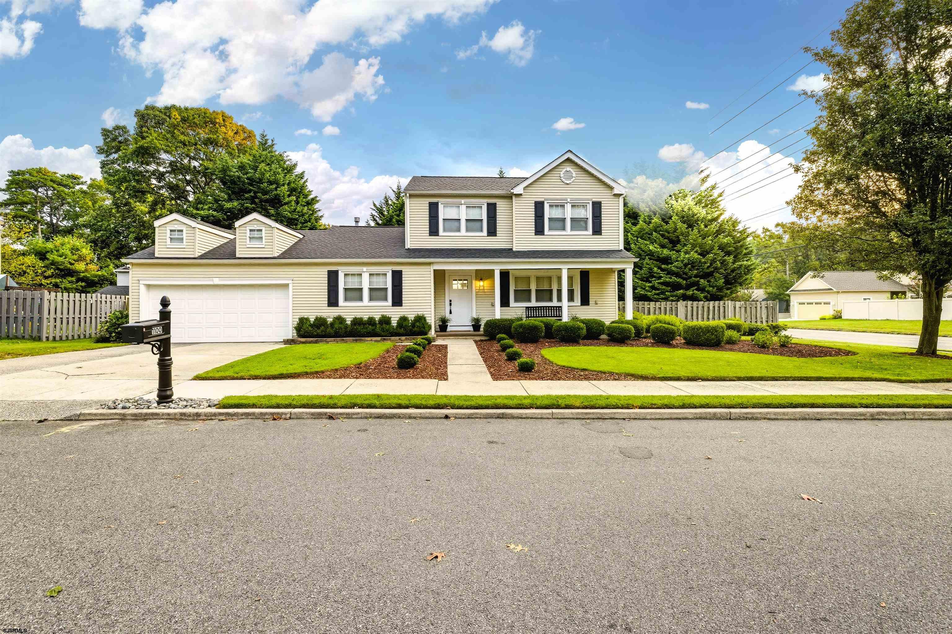 a view of house with a big yard and potted plants