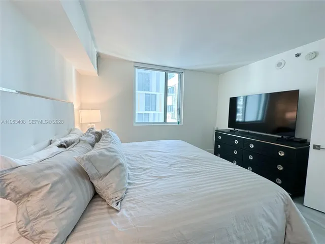 a bedroom with a bed and a large window