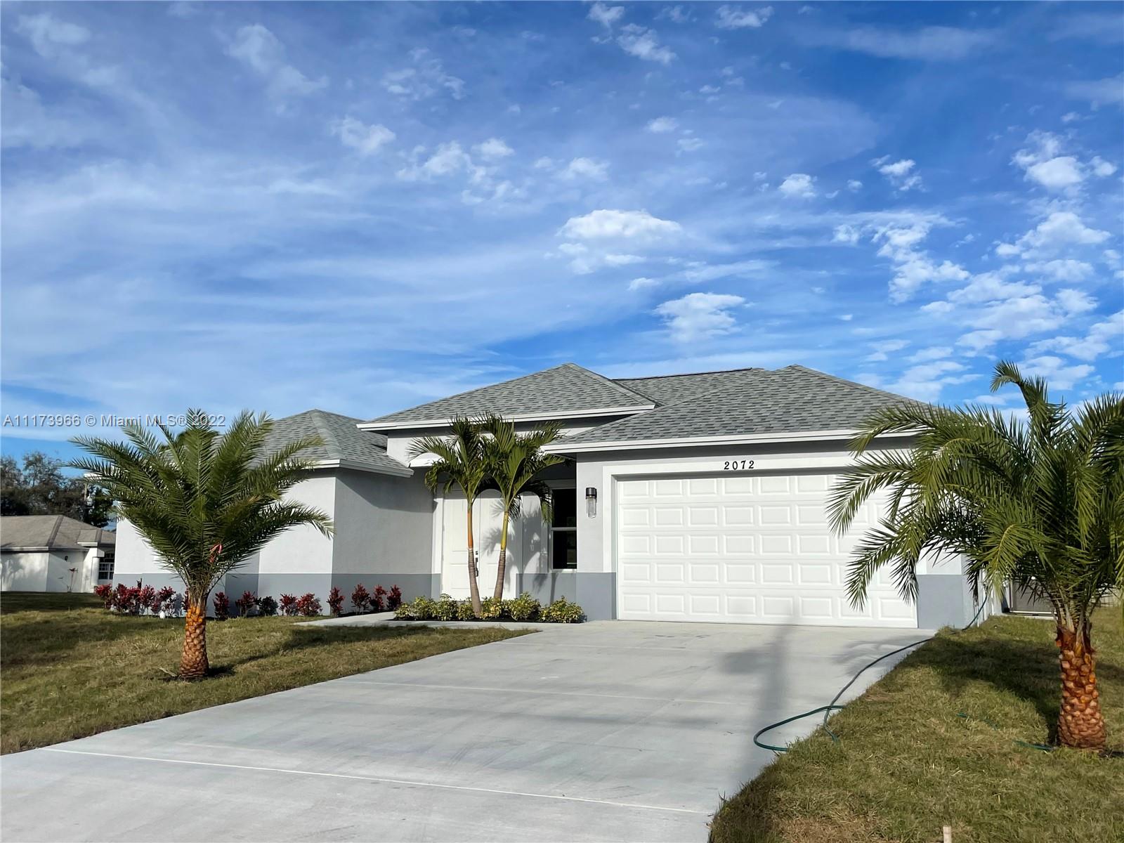 2072 Southwest Akorot Road Port St. Lucie, FL 34953 - Photo 13 of 14 a front view of a house with a yard and garage