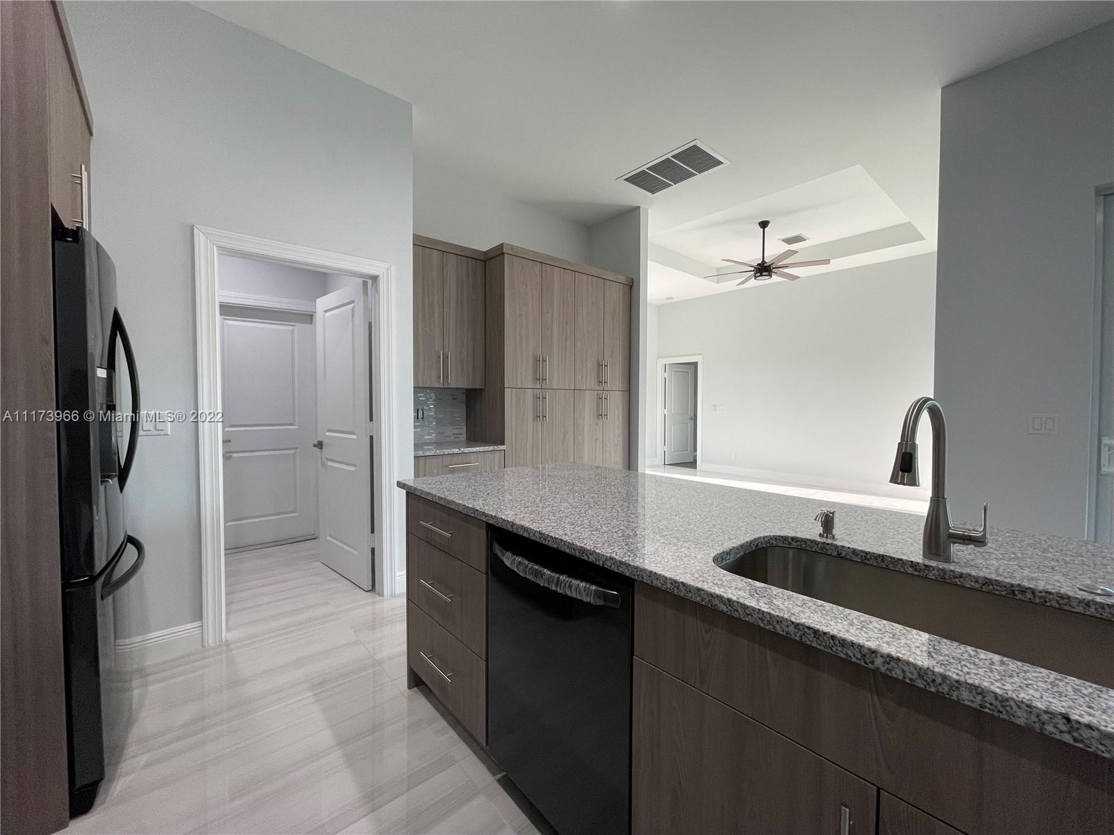 2072 Southwest Akorot Road Port St. Lucie, FL 34953 - Photo 4 of 14 a kitchen with granite countertop a refrigerator and a sink