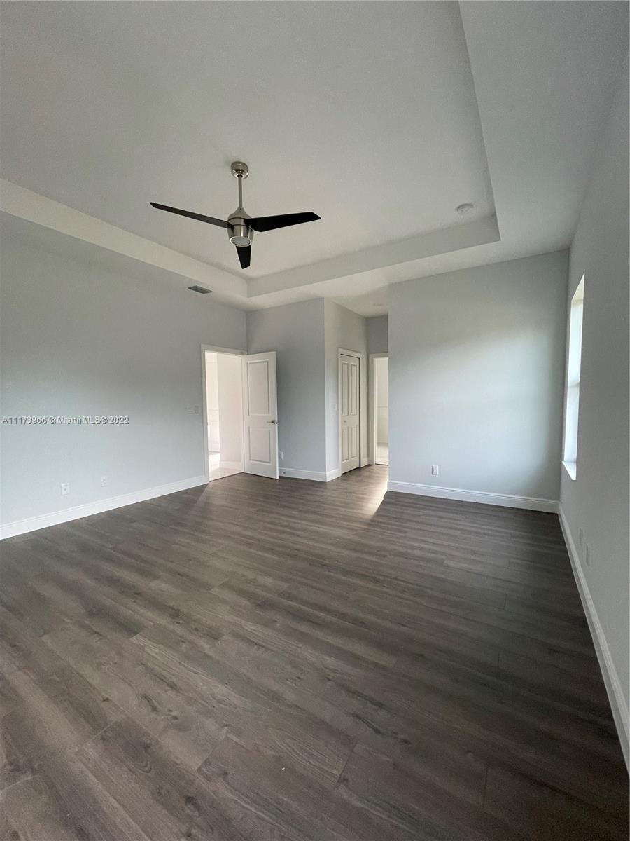 2072 Southwest Akorot Road Port St. Lucie, FL 34953 - Photo 9 of 14 a view of a room with wooden floor and ceiling fan