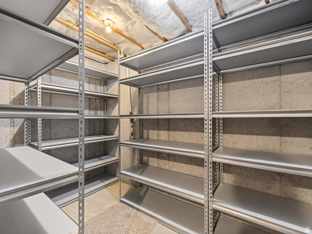 1279 West 1500th Street North Mapleton, UT 84664 - Photo 64 of 83 Expansive storage room featuring floor-to-ceiling metal shelving units, concrete walls, and overhead lighting