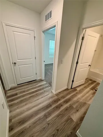 a view of a closet area with hardwood