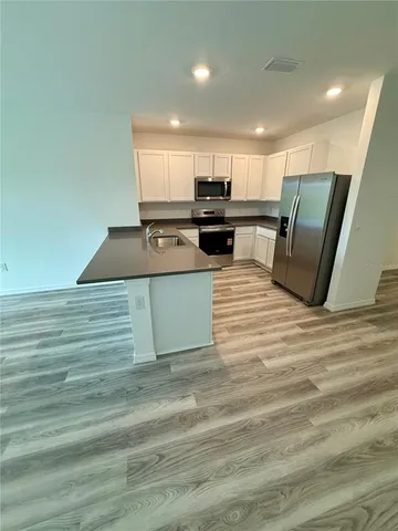 a kitchen with stainless steel appliances kitchen island sink refrigerator and stove