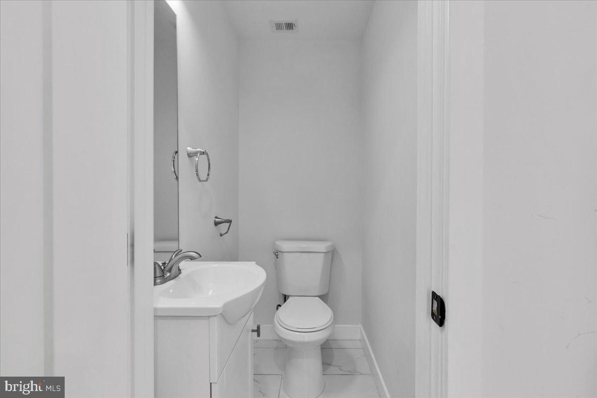 1416 22nd Street Southeast, Unit 9 Washington, DC 20020 - Photo 11 of 31 a bathroom with a toilet a sink and mirror