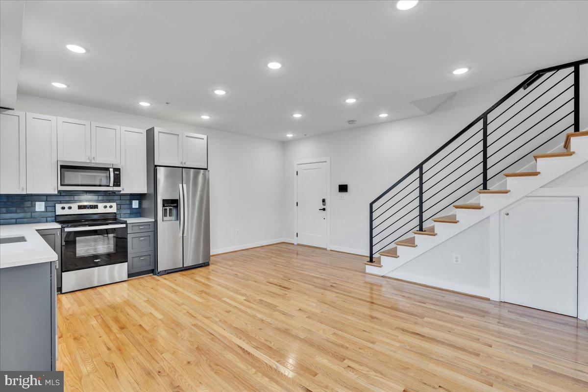 1416 22nd Street Southeast, Unit 9 Washington, DC 20020 - Photo 4 of 31 a kitchen with stainless steel appliances kitchen island granite countertop a stove a refrigerator and a sink