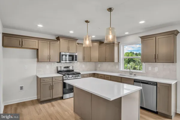 a kitchen with kitchen island a sink stainless steel appliances and cabinets