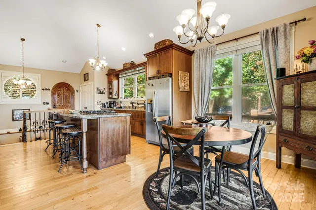 a view of a dining room and livingroom with furniture wooden floor a chandelier