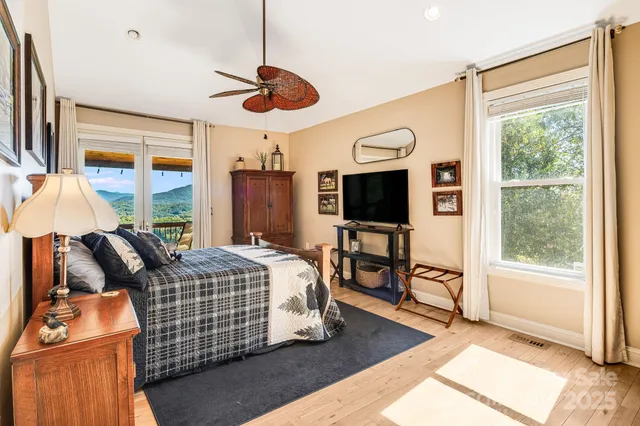 a bedroom with bed and a flat tv screen