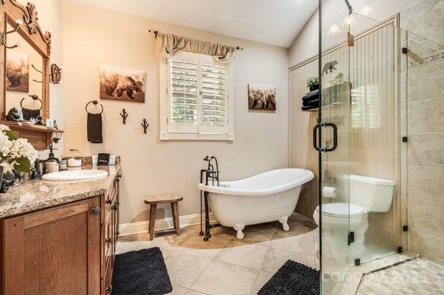 a bathroom with a granite countertop sink a toilet and shower
