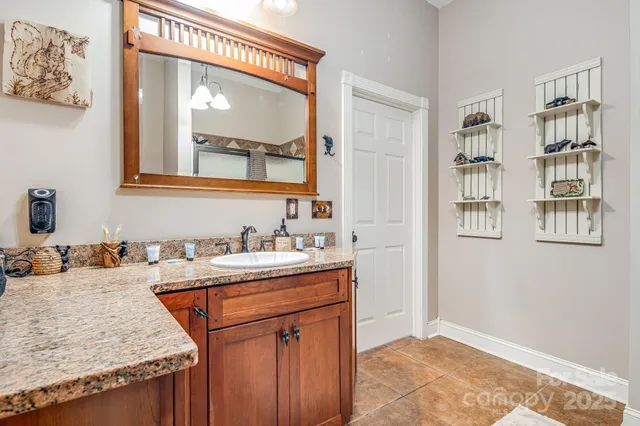 a bathroom with a granite countertop sink a vanity and a mirror