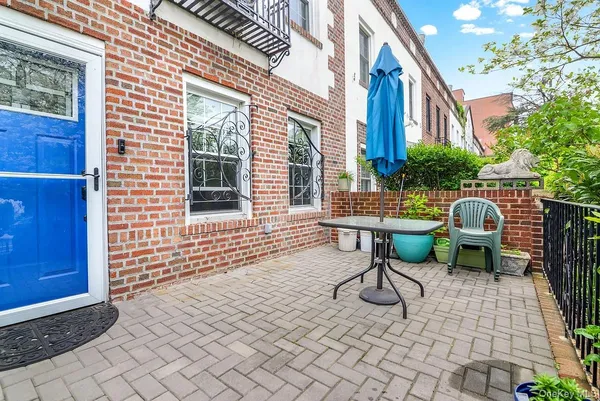 a view of a chair and table in backyard of the house