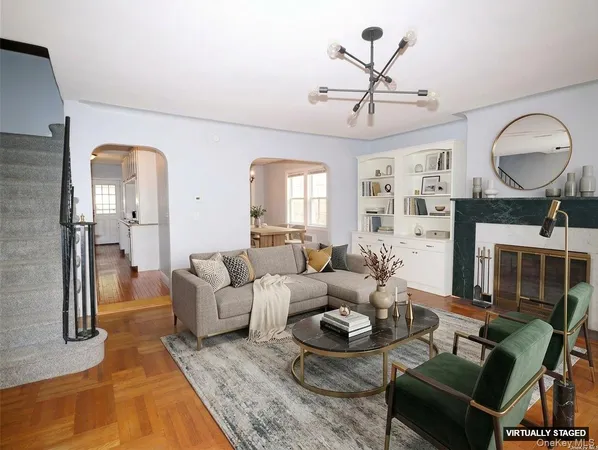 a living room with furniture a large window and a chandelier