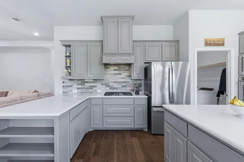 a kitchen with white cabinets and stainless steel appliances