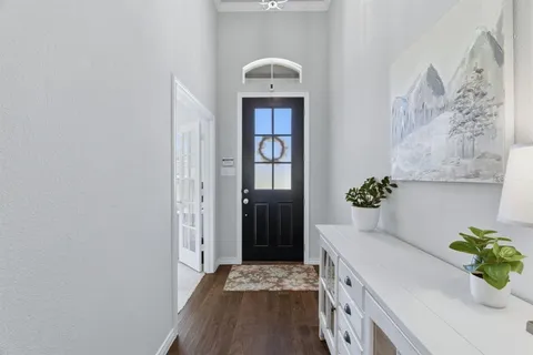 a hallway with front door and wooden floor