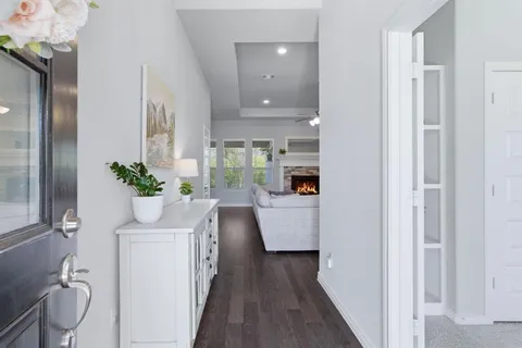 a room that has a lot of white furniture and wooden floor