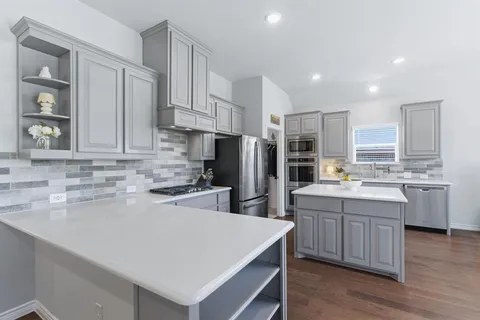 a kitchen with white cabinets and stainless steel appliances