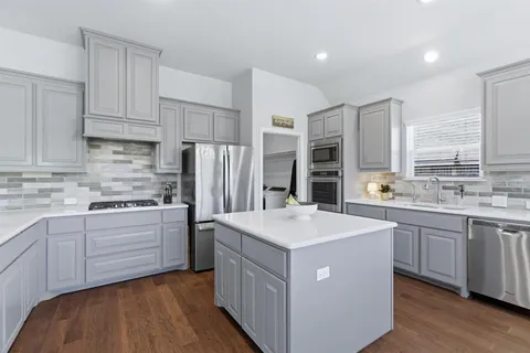 a kitchen with kitchen island white cabinets appliances and sink