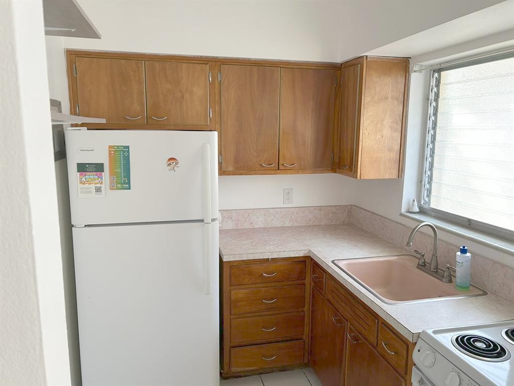 77 Hendricks Isle, Unit 9 Fort Lauderdale, FL 33301 - Photo 11 of 21 a white refrigerator freezer sitting inside of a kitchen with stainless steel appliances granite countertop cabinets and a refrigerator