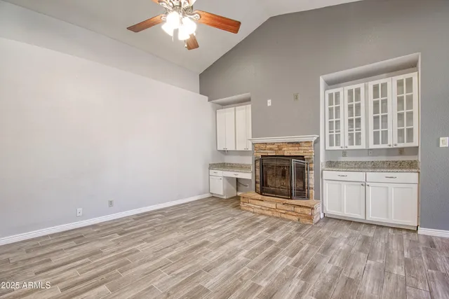 an empty room with a fireplace and wooden floor