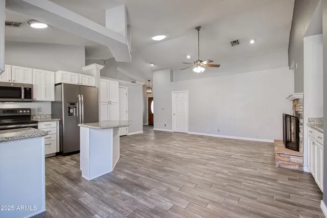 a view of a kitchen with refrigerator and wooden floor