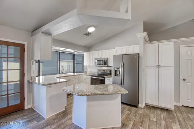 a kitchen with stainless steel appliances granite countertop a stove refrigerator and cabinets