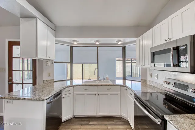 a kitchen with stainless steel appliances granite countertop a stove and cabinets