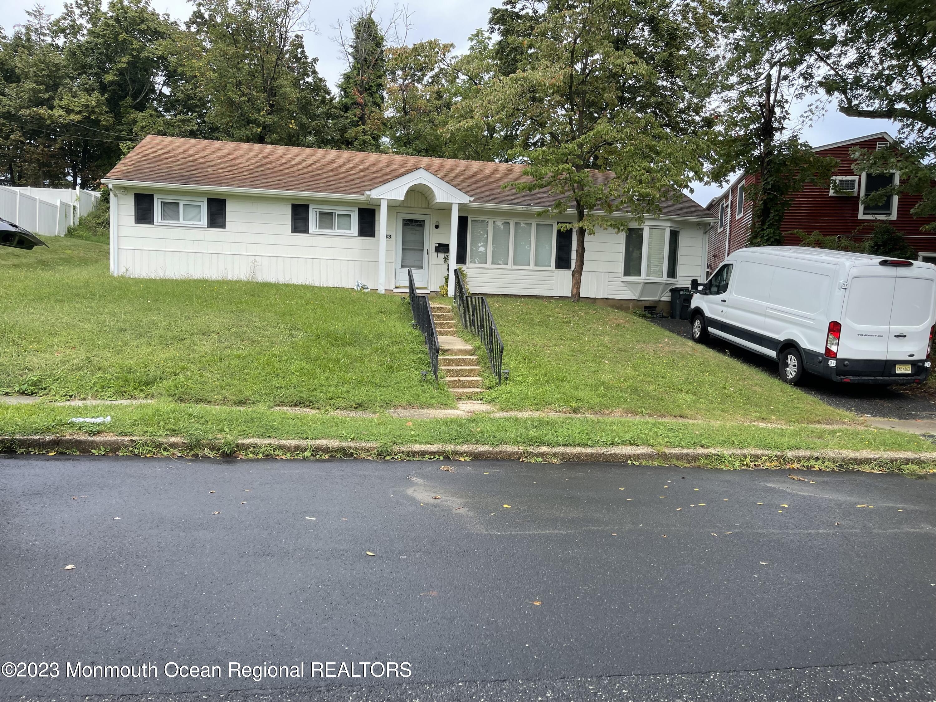 233 Royal Place Elberon, NJ 07740 - Photo 1 of 10 a front view of a house with a yard and garage