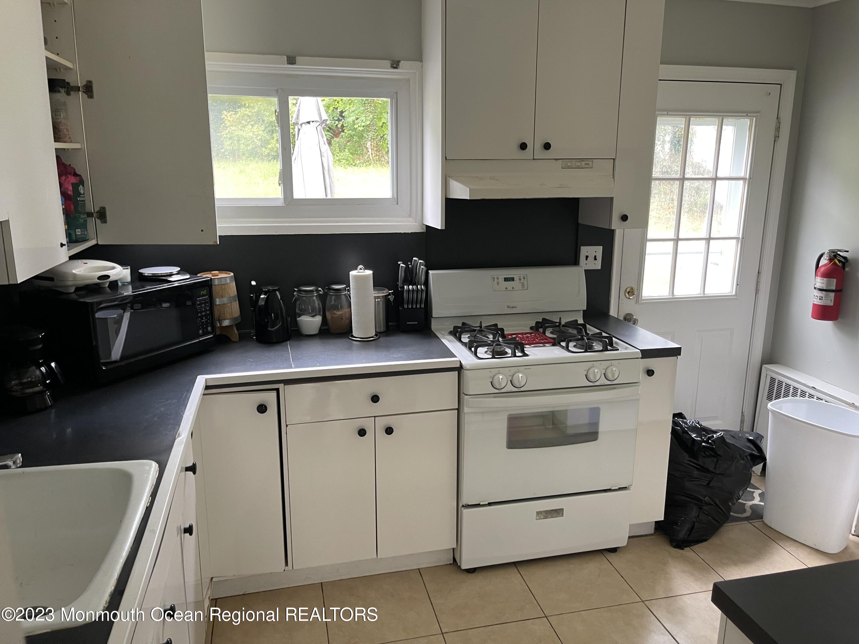 233 Royal Place Elberon, NJ 07740 - Photo 2 of 10 a kitchen with granite countertop white cabinets and white appliances