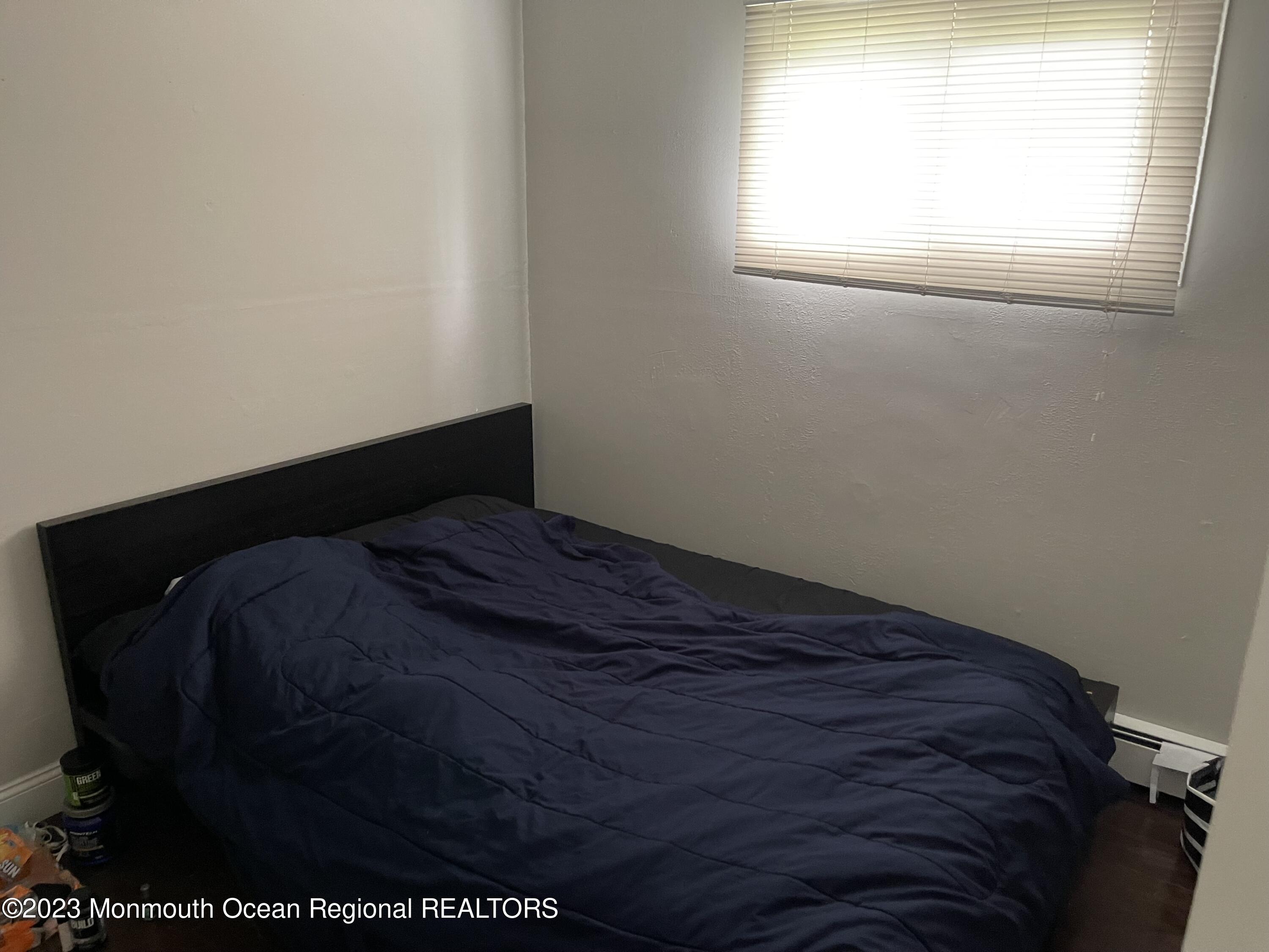 233 Royal Place Elberon, NJ 07740 - Photo 6 of 10 a bed sitting in a bedroom next to a window