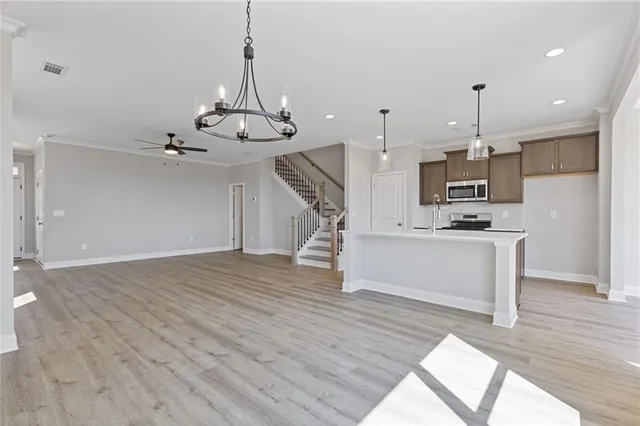 a view of kitchen with cabinets stainless steel appliances and wooden floor