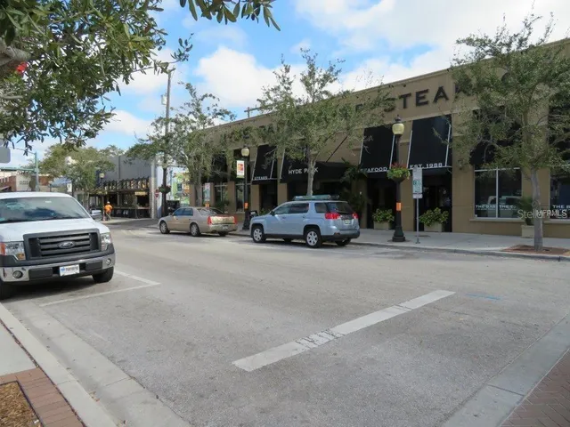 an aerial view of a house with outdoor space and a car park in front of building