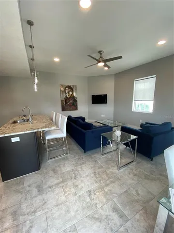 a living room with couches and a potted plant