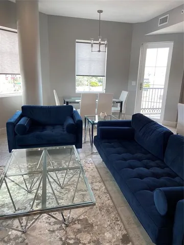 a living room with lots of furniture and kitchen view
