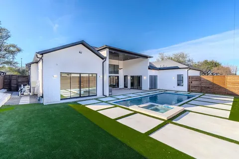 a view of a house with a swimming pool and a yard