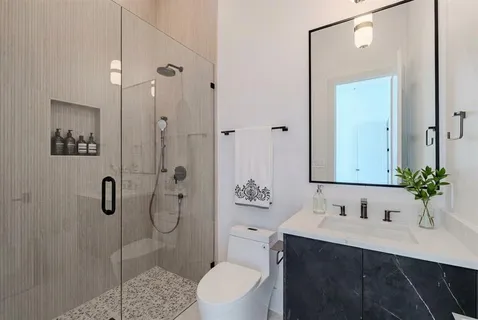 a bathroom with a sink toilet a mirror and shower