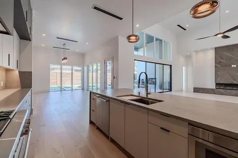 a kitchen with stainless steel appliances granite countertop a sink a stove and a wooden floors