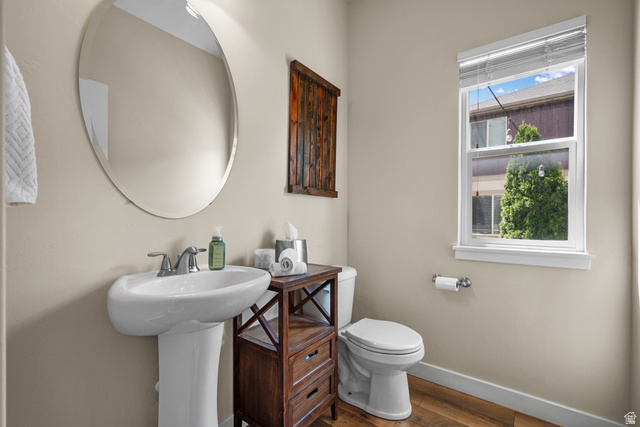 955 Delorean Lane Midvale, UT 84047 - Photo 17 of 47 Pedestal sink with chrome faucet, oval wall mirror, and wood-finish flooring