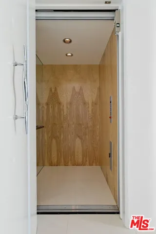 a bedroom with a bed a large window and a lamp