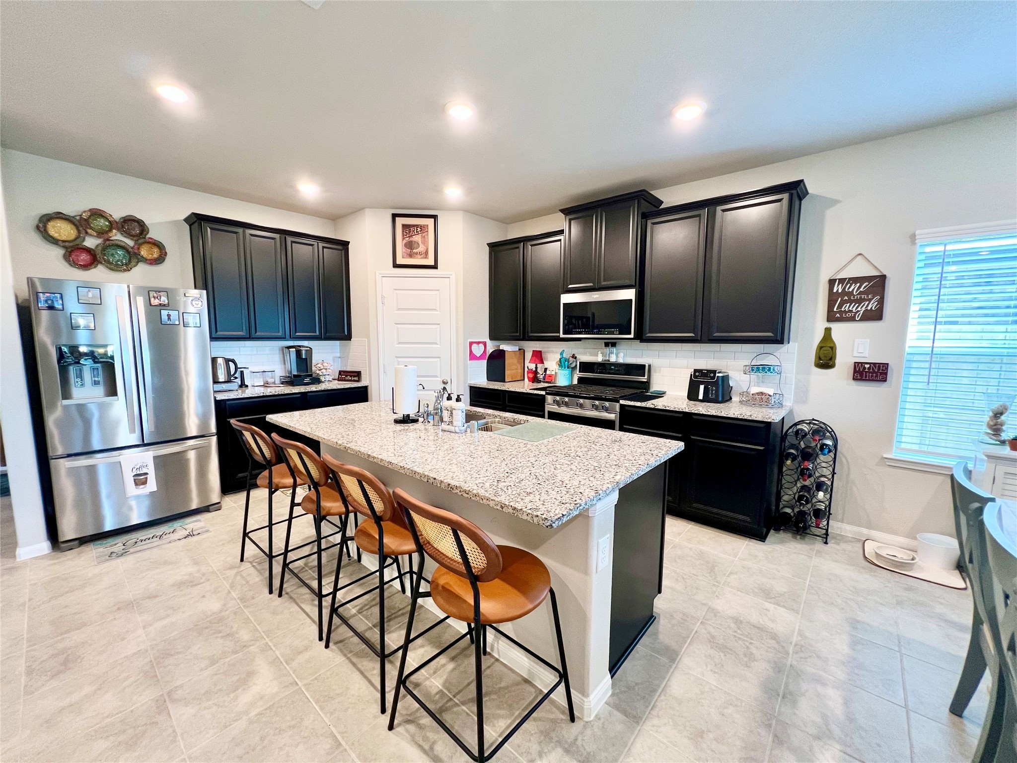 10013 Hermann Trace Texas City, TX 77591 - Photo 6 of 22 a kitchen with stainless steel appliances kitchen island granite countertop a refrigerator a stove a microwave a sink dishwasher and white cabinets with wooden floor