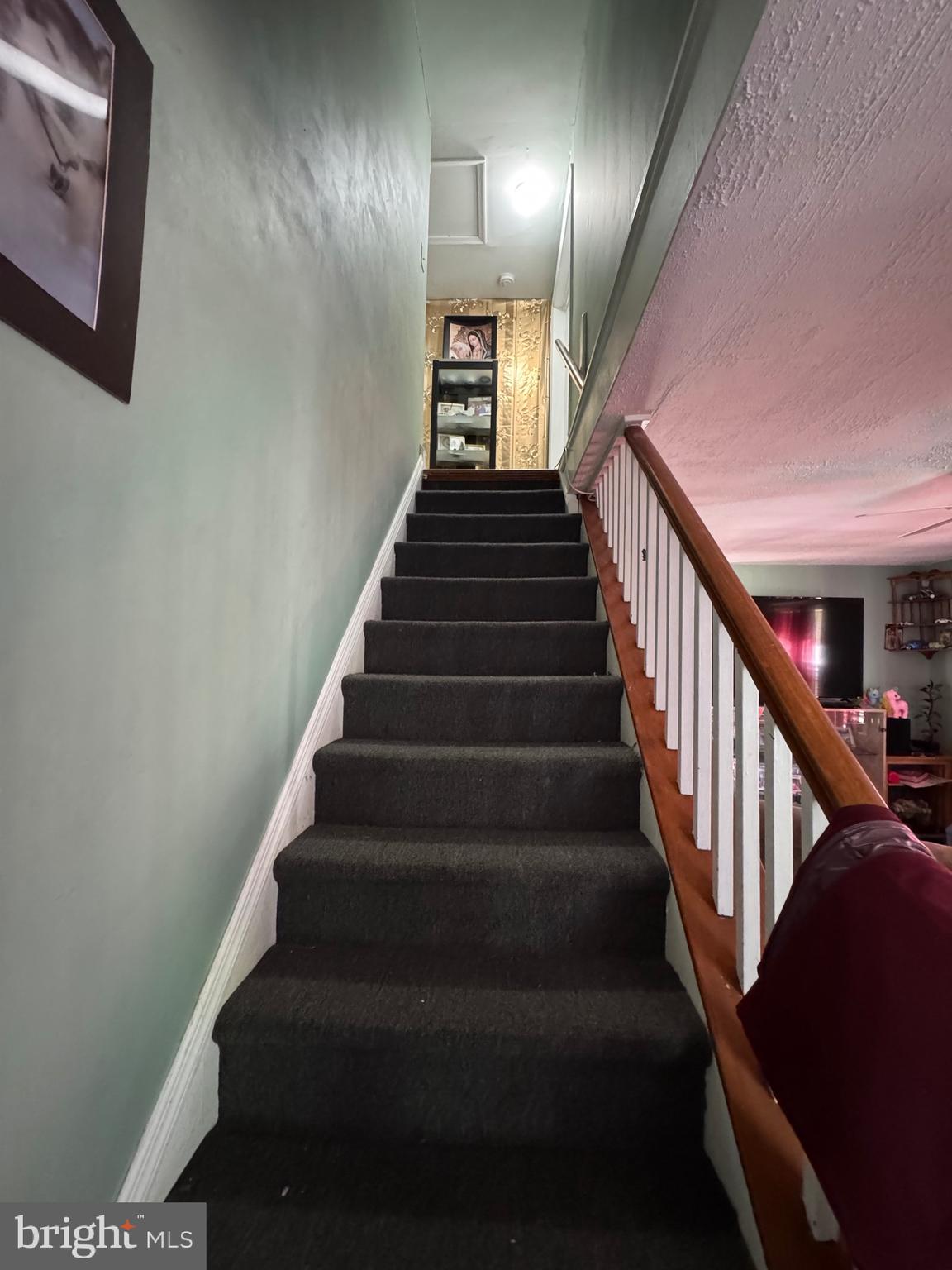 1515 Collings Road Camden, NJ 08104 - Photo 11 of 23 a view of staircase with lots of frames on wall and wooden floor