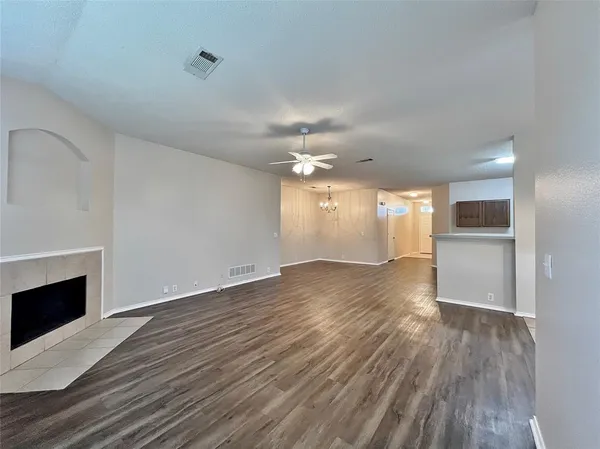 a view of a room with wooden floor and kitchen view