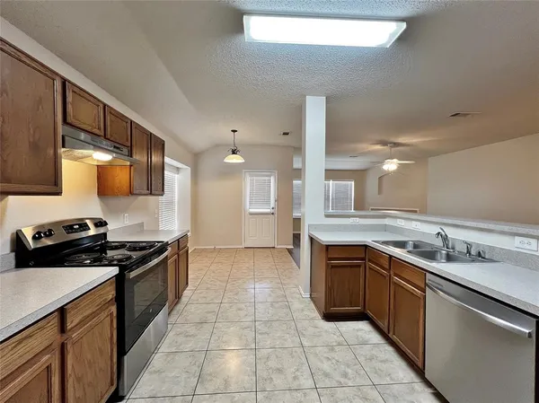 a kitchen with stainless steel appliances granite countertop a sink and a stove