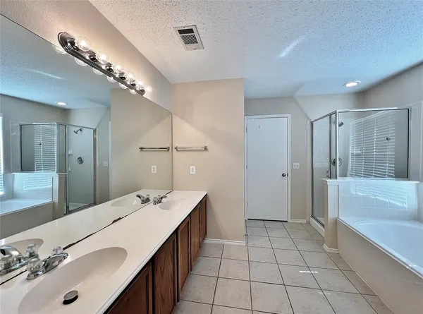 a spacious bathroom with a bathtub shower sink and mirror