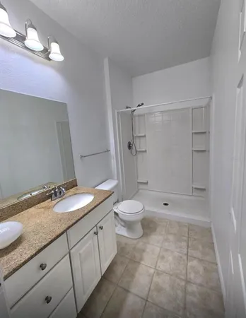 a bathroom with a granite countertop sink toilet and shower