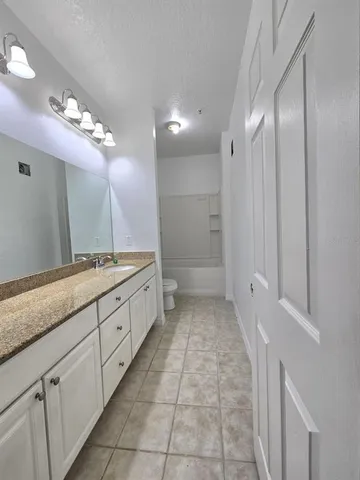 a spacious bathroom with a granite countertop sink a mirror and a shower