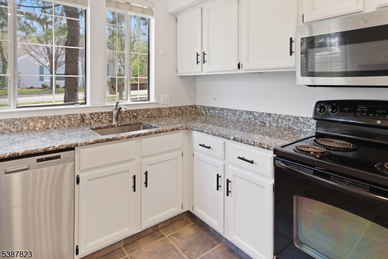 93 Birchwood Road Bedminster, NJ 07921 - Photo 4 of 18 a kitchen with granite countertop white cabinets and a stove