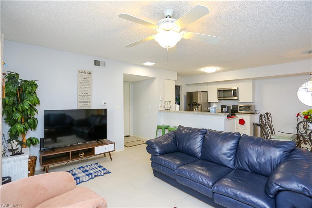 2214 Arbour Walk Circle, Unit 2012 Naples, FL 34109 - Photo 14 of 29 a living room with furniture and a flat screen tv